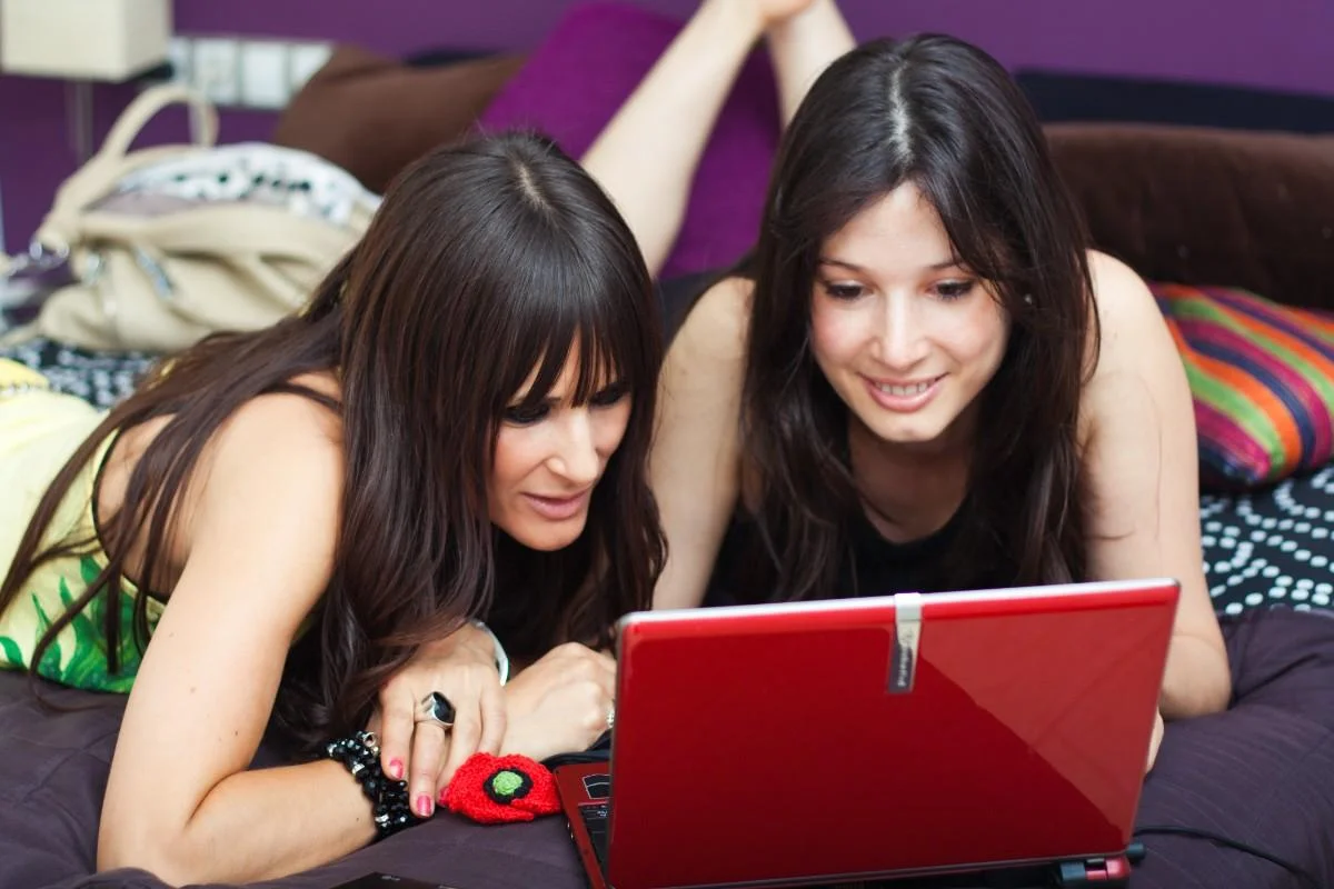 Two women using a laptop together, exploring internet slang meanings and fun online words used in digital communication.